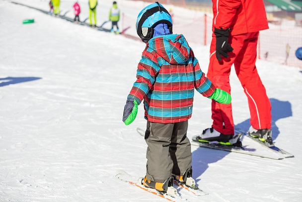 Dziecko uczy się jeździć na nartach